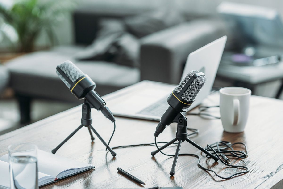 Deux micros de podcast posés sur une table basse dans un salon lumineux